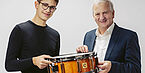 On the left is a young man, on his right is Josef Ortner. Both are holding a drum together.
