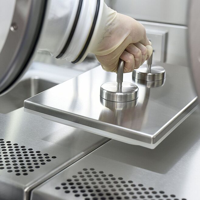  A hand, using a glove attached to the insulator's disc, lifts a plate to which a handle is mounted.