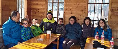 Stefan Rud is sitting at a table together with three girls and three boys and one man.