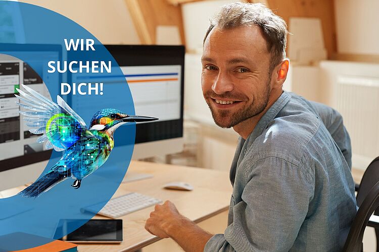 Zufriedener Mitarbeiter sitzt vor Computer.