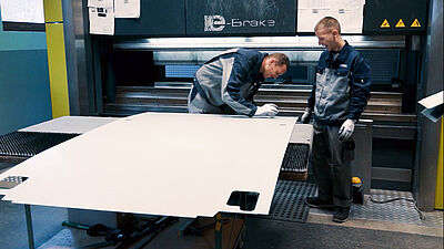 Two men are working on a plate in production.